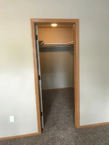 A closet with a door open and the lights on.