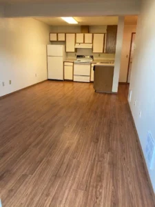 A kitchen with wood floors and white appliances.